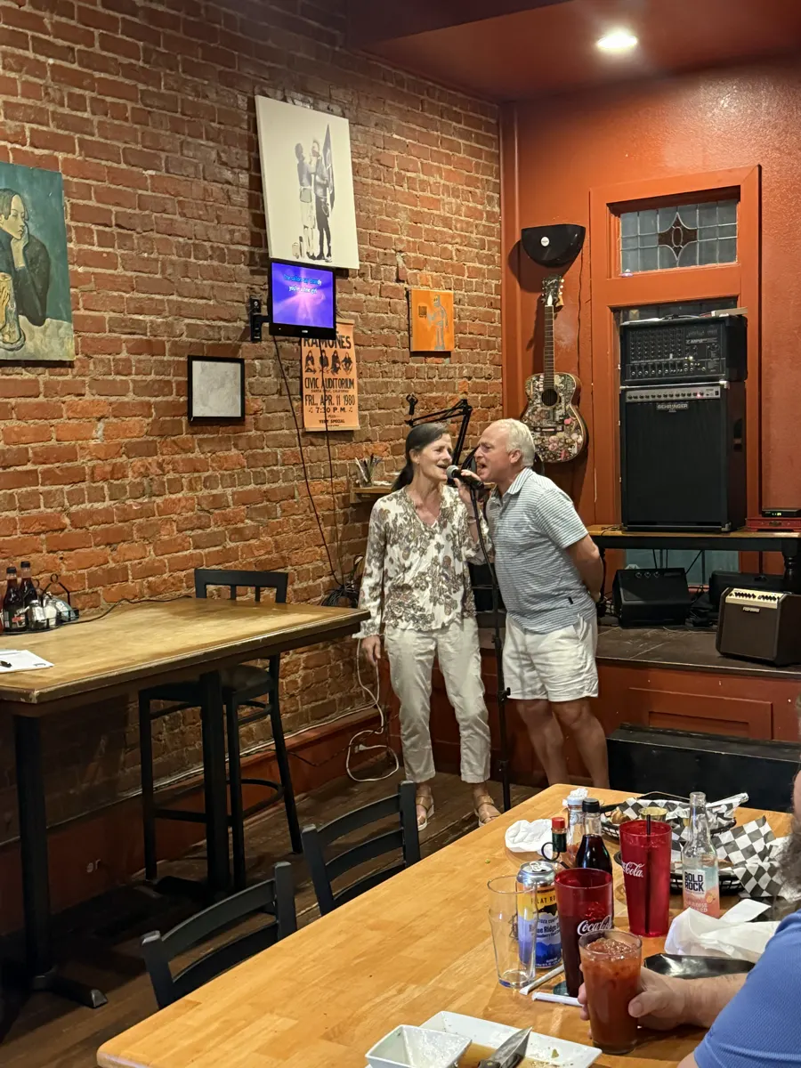 Singing into the mic on a live music night in a brick-walled pub in town