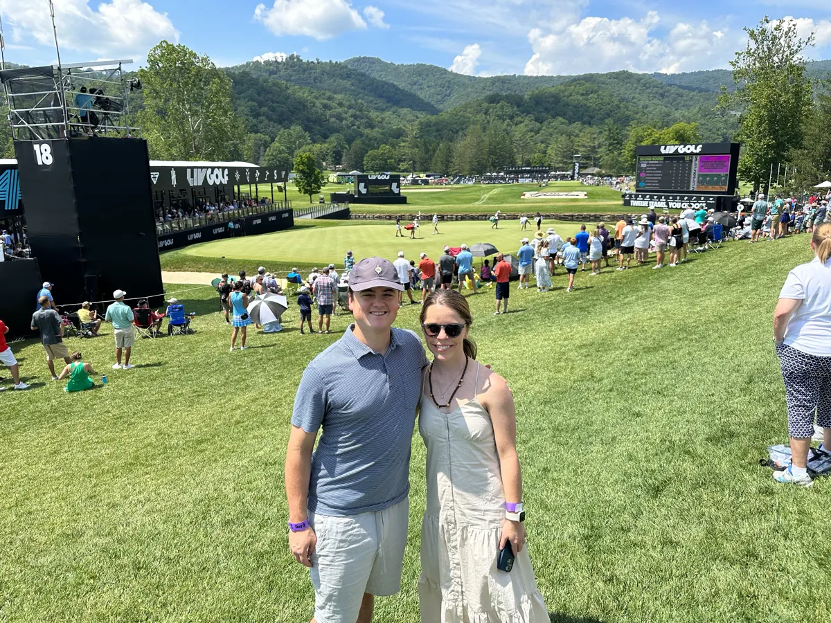 Shelby and Hobey at a golf tournament with the mountains behind the course